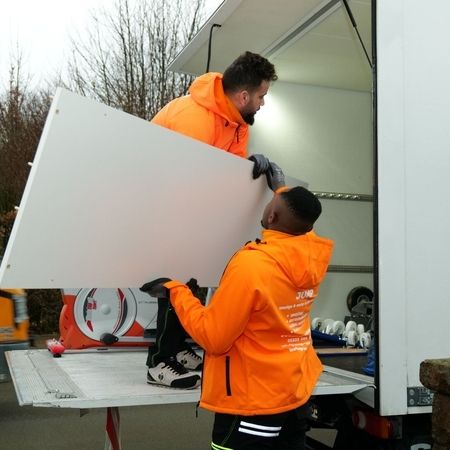 Mitarbeiter von Jump laden ein Möbelteil in einen Transporter ein