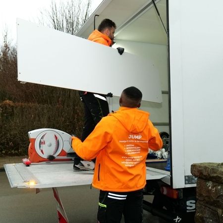 Mitarbeiter von Jump laden ein Möbelteil in einen Transporter ein